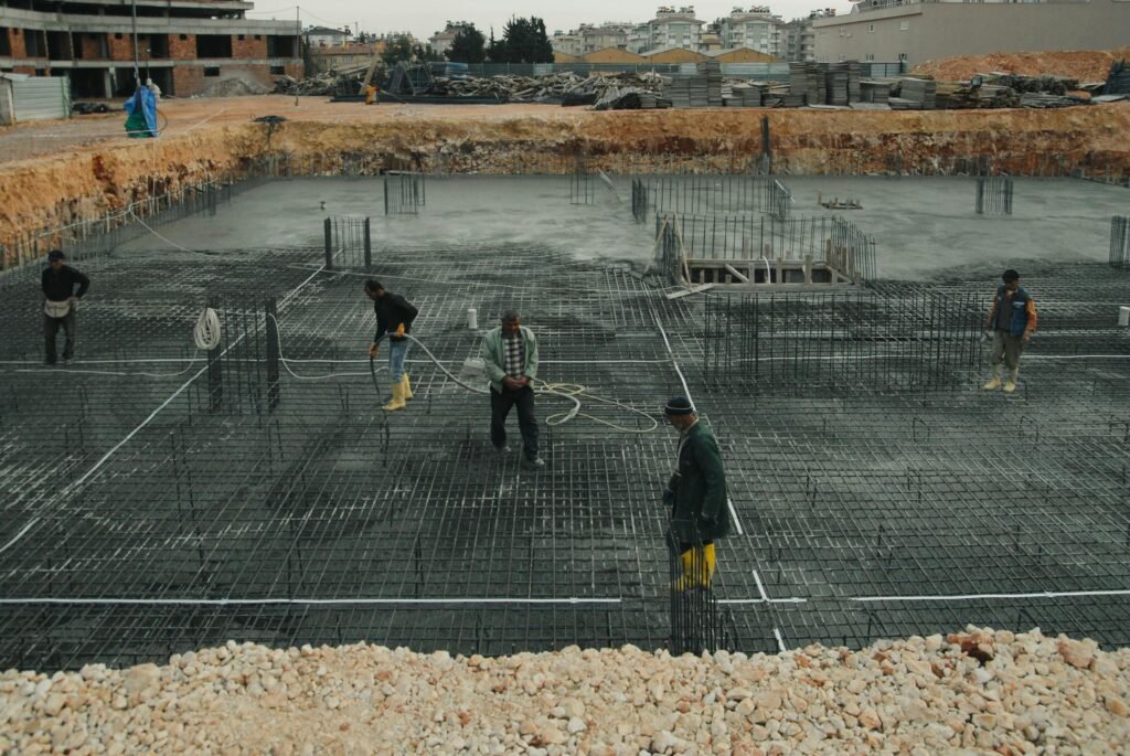 Industrial construction site with workers managing steel reinforcements.