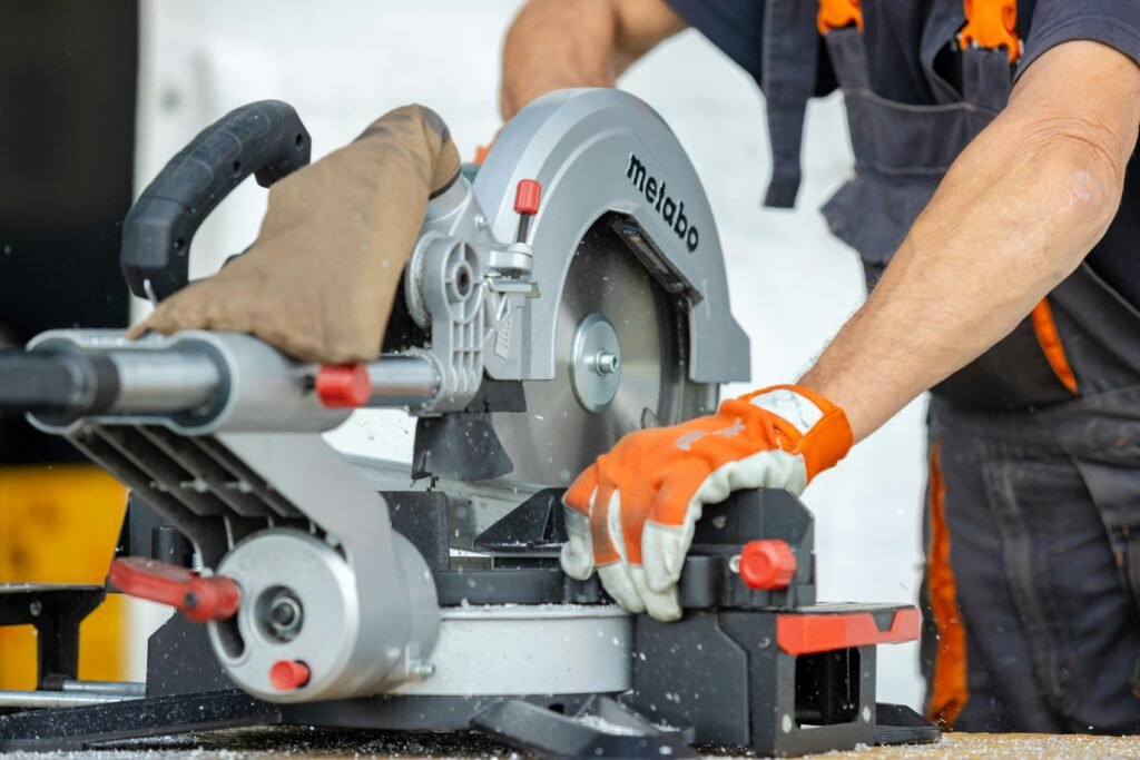 Focused worker using a metal saw for precise cutting at a construction site.