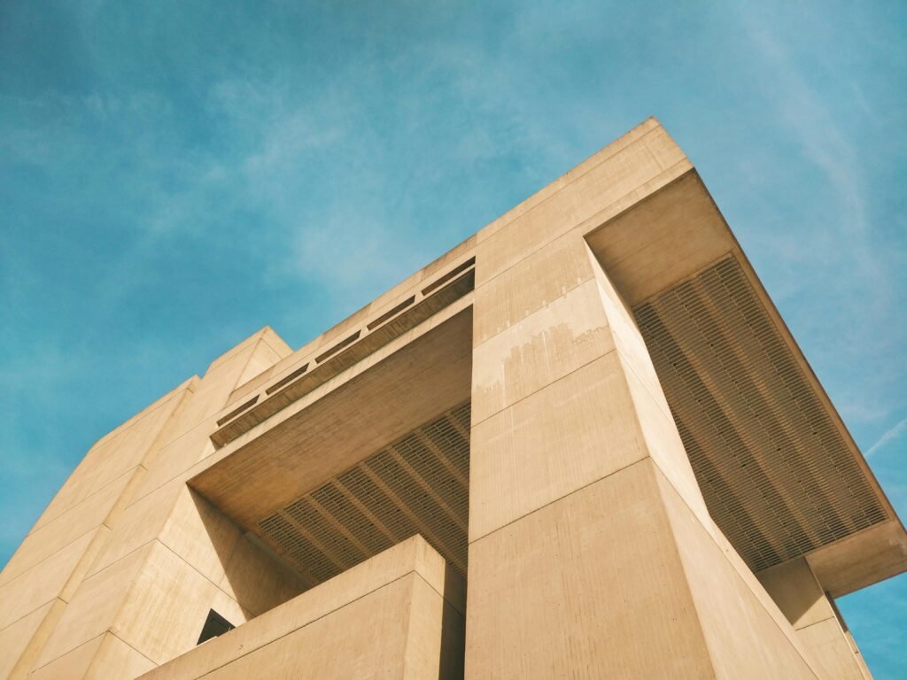 Low-angle view of a modern building in Ithaca, NY, set against a vibrant blue sky.