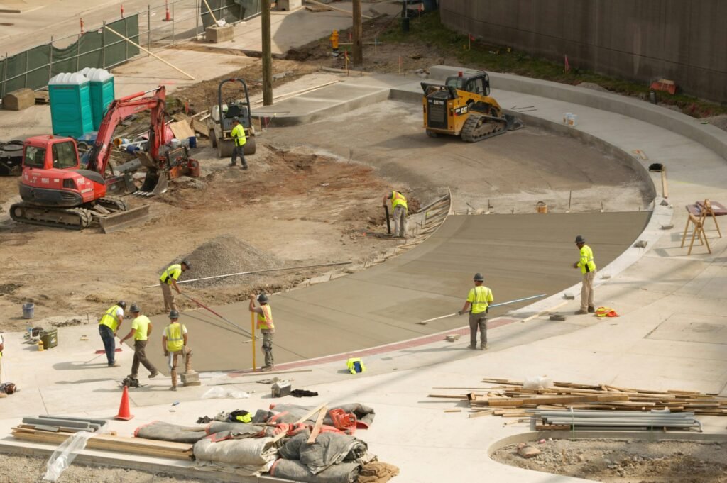 Construction workers paving concrete at a bustling site in Covington, KY.