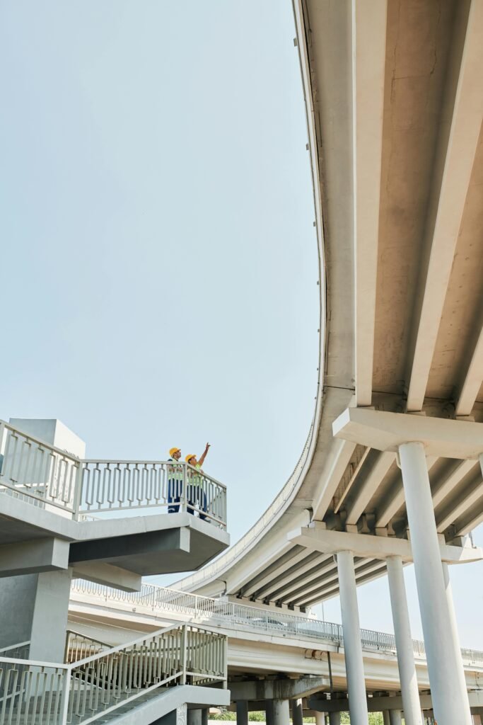 Construction worker inspects bridge structure, highlighting modern architecture.